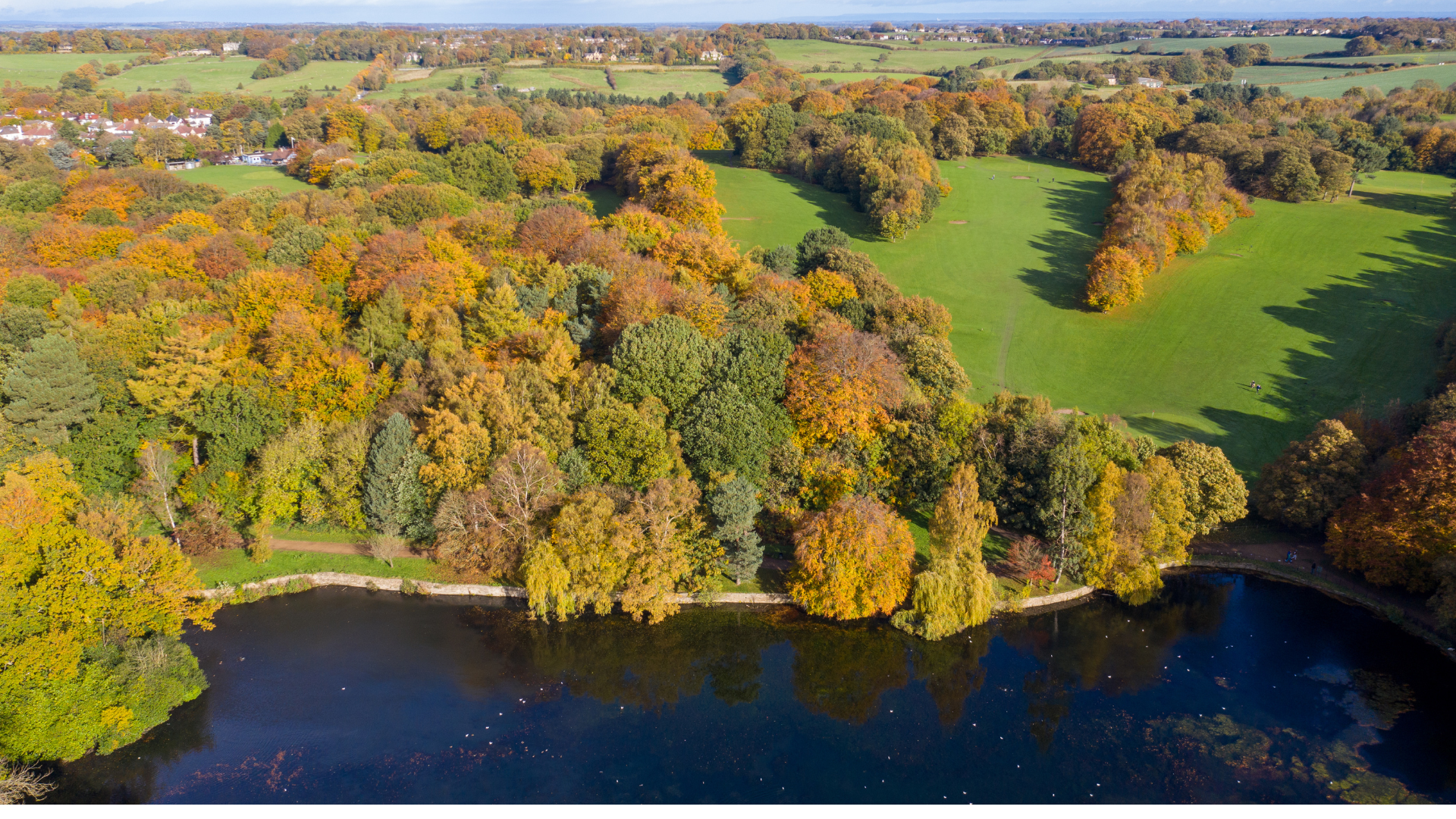 An aerial photo of Roundhay Park in the autumn showing the orange and brown leaves on the trees and the lake