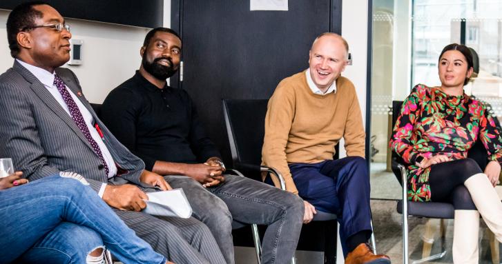 A group of four people involved in a panel conversation on innovation chaired by Tom Riordan