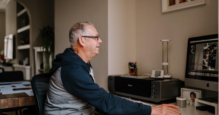 Older man working at computer age positive