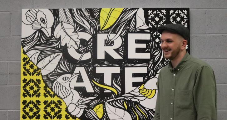 Artist stood next to his artwork