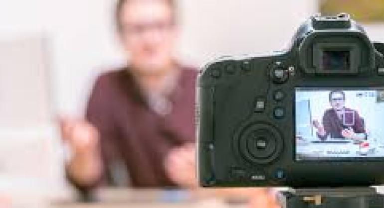 Image of a man been filmed and a camera filming 
