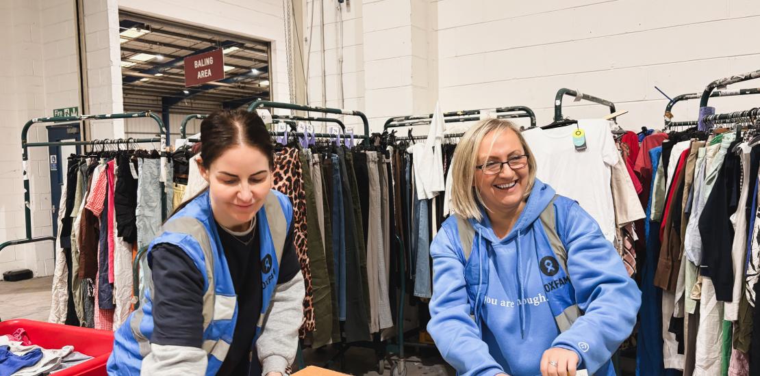 Two volunteers arranging donated clothes