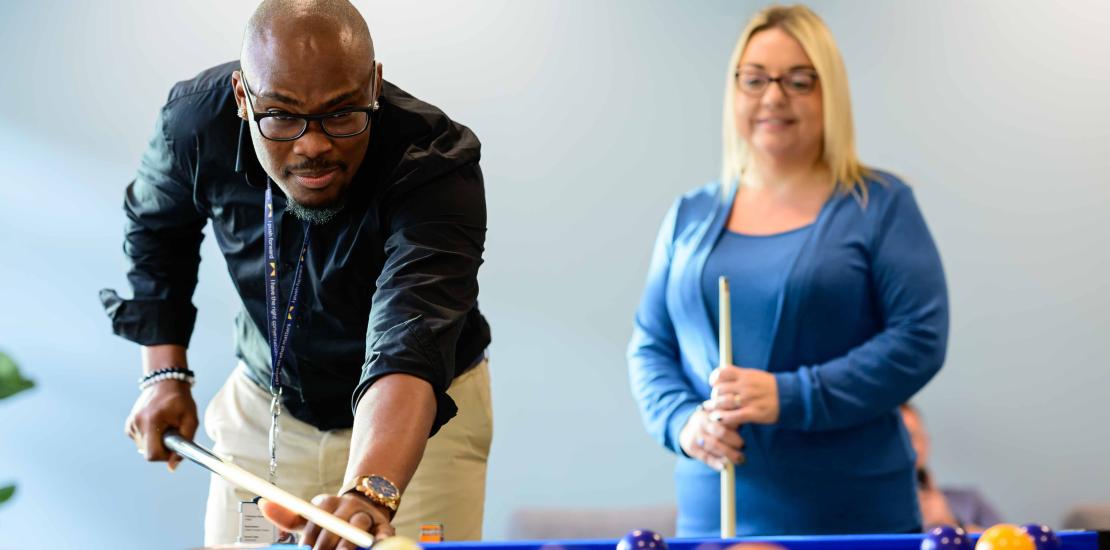 Two colleagues play pool